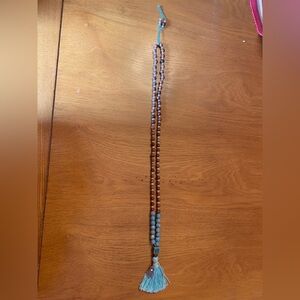 Wood and ceramic beaded necklace with tassel pendant with a Hamsa charm